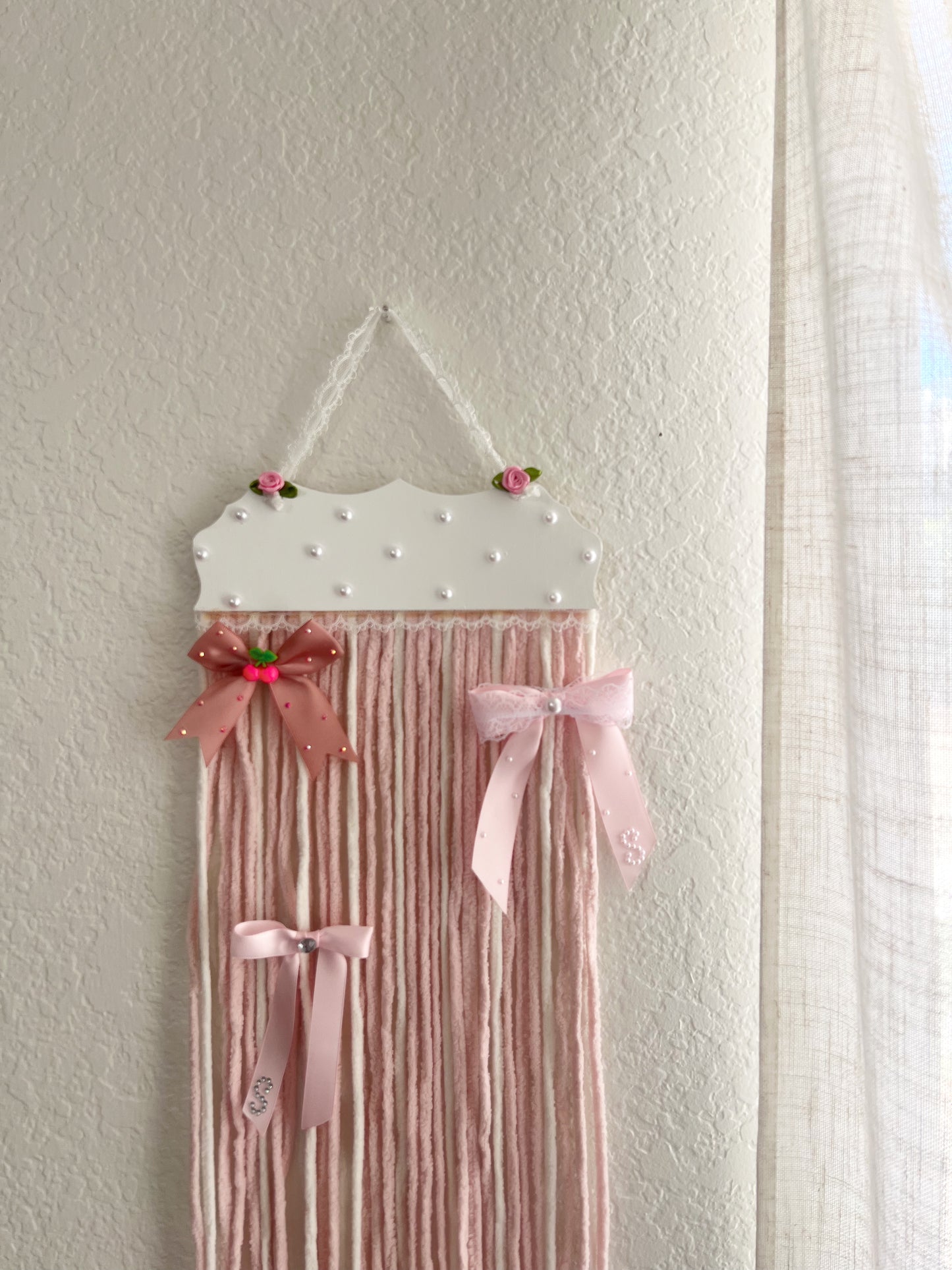 The soft pink yarn bow holder