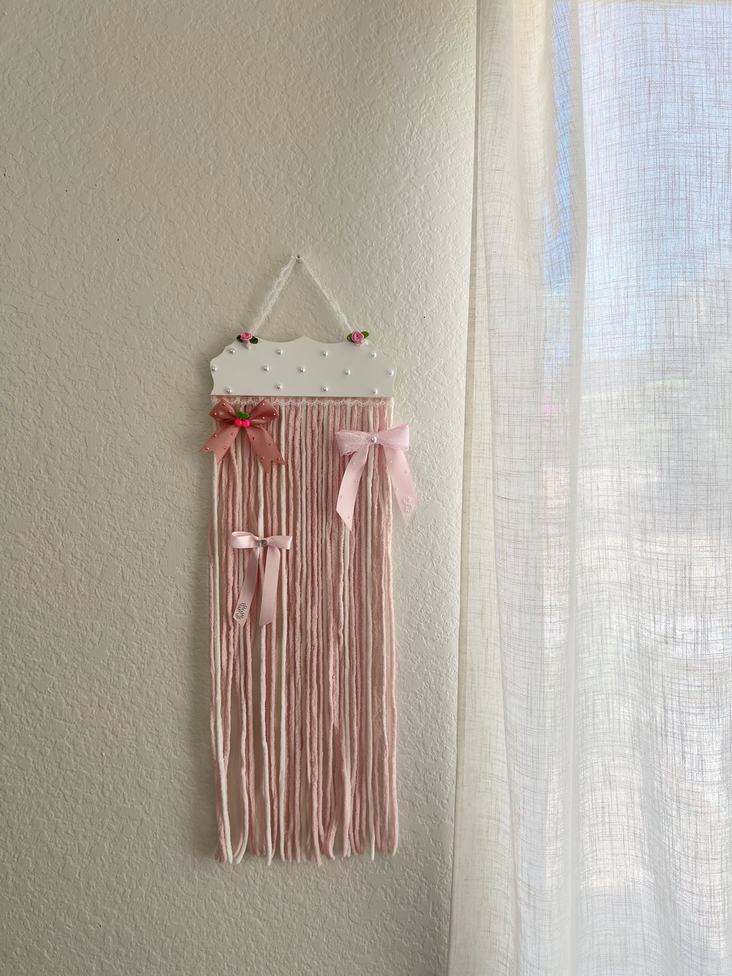 The soft pink yarn bow holder