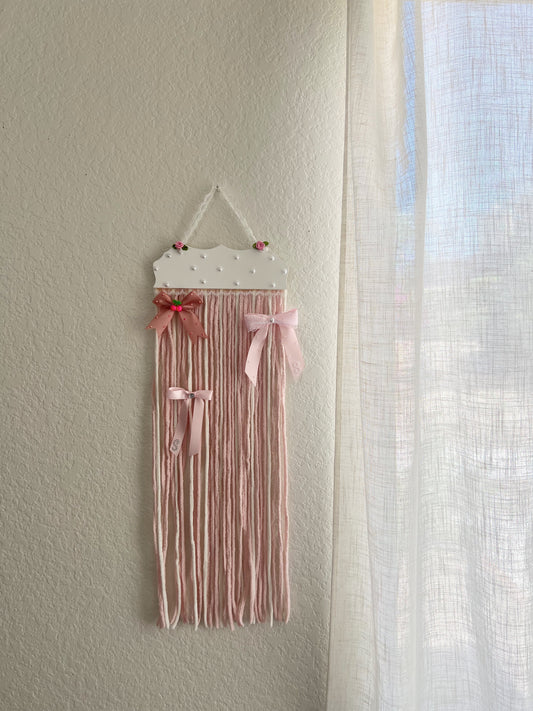 The soft pink yarn bow holder